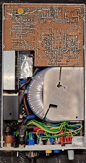 Innenansicht eines elektronischen Geräts mit Leiterplatte und Transformator