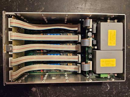 Innenansicht eines Netzteils mit Flachbandkabeln und Transformatoren