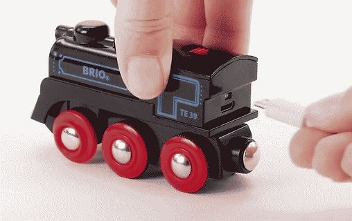 Hand steckt USB-Kabel in Spielzeuglokomotive