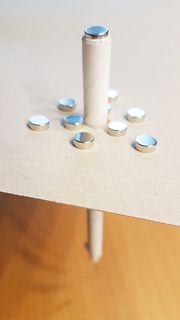 Stift und kleine Magnete auf Tischfläche