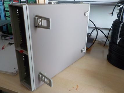 Grauer Kunststoffgehäuse auf einem Holztisch