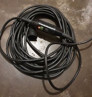 Aufgewickeltes schwarzes Kabel mit Schalter und Steckdose