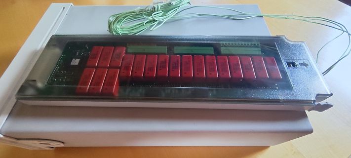 Elektronikmodul mit roten Bauteilen in Gehäuse