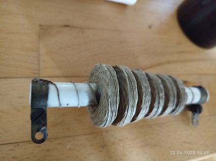 Spule auf weißem Rohr auf Holzuntergrund