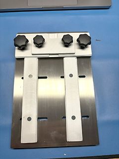 Metallhalterung mit vier schwarzen Drehknöpfen