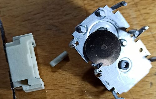 Zerlegtes Bauteil, vermutlich ein Schalter oder Sensor