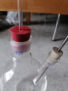 Laboroberfläche mit Glasapparatur und Stopfen