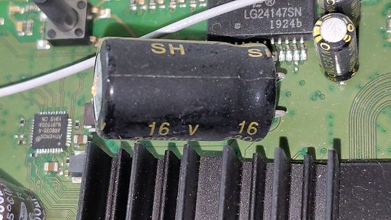 Nahaufnahme einer Leiterplatte mit Elektrolytkondensator und Kühlkörper