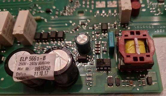 Nahaufnahme einer Leiterplatte mit Elektrolytkondensatoren und Transformator