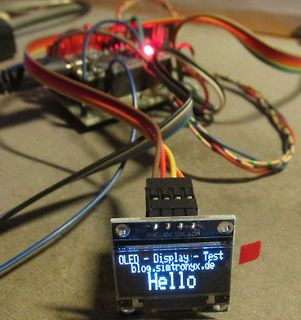OLED-Display mit Verkabelung auf einem Mikrocontroller-Aufbau