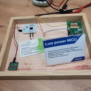 Elektronik-Aufbau mit Leiterplatten und Informationskarte auf Holzbrett