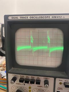 Abfotografiertes Oszilloskop mit grünem Signalverlauf