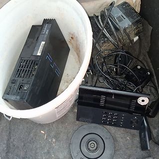 Alte Elektronikgeräte und Kabel in einem Eimer