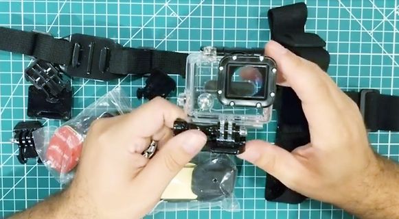 Hände halten Actioncam-Gehäuse und Zubehör