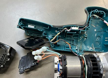 Zerlegtes elektronisches Gerät mit Kabeln und Gehäuseteilen