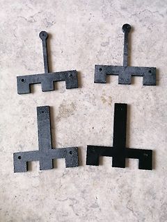 Vier schwarze Kunststoffteile auf Steinuntergrund