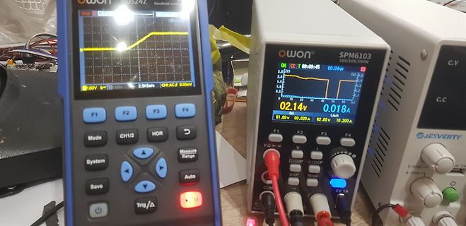 Handheld-Oszilloskop und Netzteil auf einem Arbeitstisch