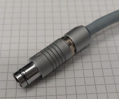 Stecker eines grauen Kabels auf Millimeterpapier