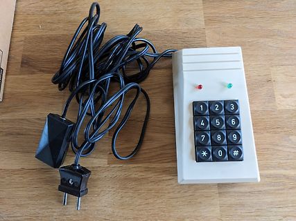 Altes Tastaturgerät mit Netzteil auf Holztisch