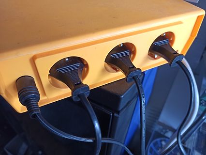 Gelbe Steckdosenleiste mit eingesteckten Netzteilen