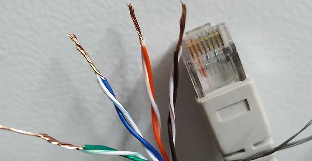 Abisolierte Adern eines Ethernet-Kabels und RJ45-Stecker