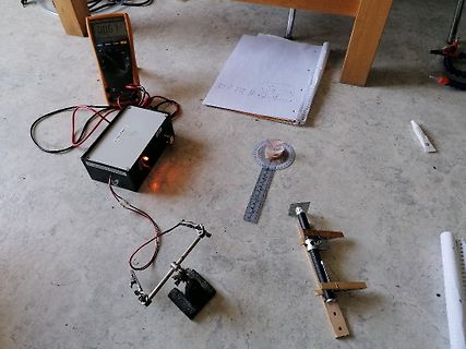 Elektronischer Versuchsaufbau mit Multimeter, Netzteil und Messvorrichtung