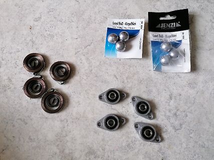 Bleikugeln und Metallteile auf Untergrund