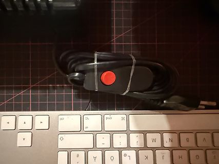 Netzkabel auf Tastatur und Schneidematte