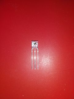 Transistor mit drei Anschlüssen auf rotem Grund