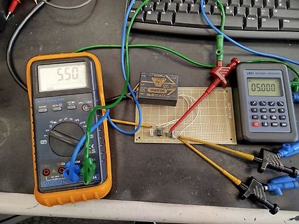 Elektronik-Aufbau mit Multimetern und Netzteil auf Lochrasterplatine