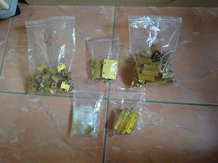 Mehrere kleine Plastiktüten mit goldfarbenen Bauteilen
