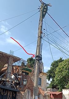 Strommast mit Kabeln und einem roten Pfeil
