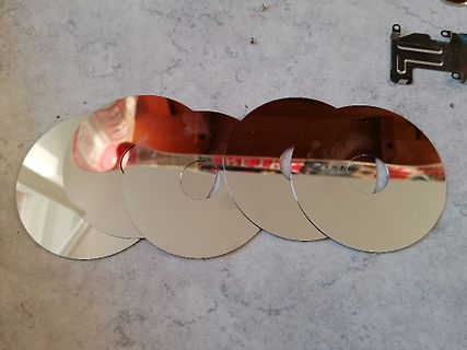 Fünf glänzende CD-Rohlinge auf einer Arbeitsfläche