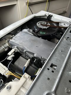 Innenansicht einer Waschmaschine mit Motor und Antriebsriemen