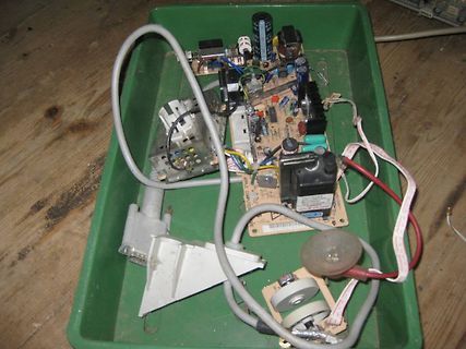 Elektronikbauteile und Leiterplatten in einer grünen Schale