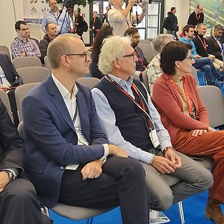 Personen sitzen in einem Konferenzraum