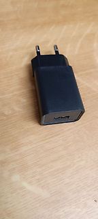 Schwarzer Netzadapter auf Holzuntergrund