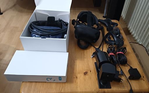 VR-Headset mit Zubehör und Verpackung auf Holztisch