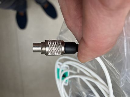 Stecker eines Netzteils in einer Hand