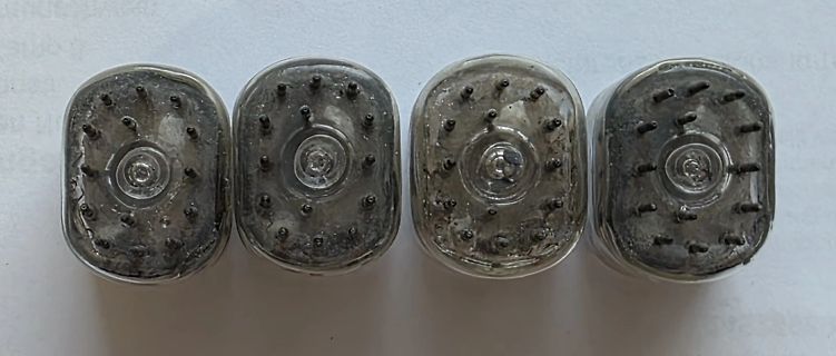 Vier transparente Bauteile mit Metallstiften