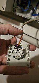Hand hält Anschlusskabel und Stecker eines Bauteils
