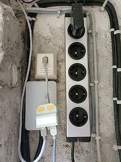 Steckdosenleiste und Kabel an einer Wand