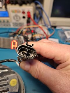Hand hält elektrischen Stecker in Werkstatt