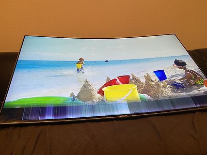 Abfotografierter gekrümmter Monitor mit Strandmotiv