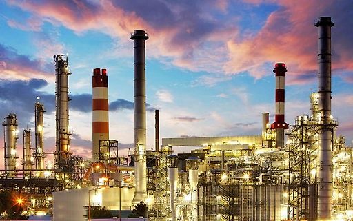 Industrieanlage mit Schornsteinen bei Dämmerung