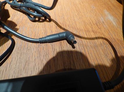 Netzteil-Stecker und Kabel auf Holzuntergrund