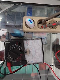 Analogmultimeter, Steckdose und weißes Gerät