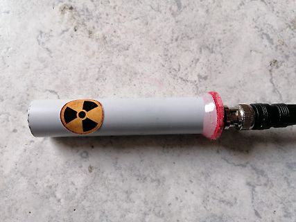 Grauer Zylinder mit Radioaktivitäts-Symbol und Stecker
