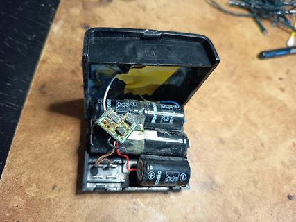 Geöffnetes Batteriefach mit ausgelaufenen Batterien und Platine