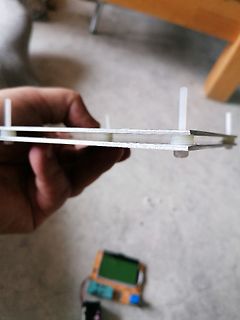 Hand hält Platine über Display und Elektronik